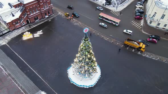 Luxurious Christmas Tree with Glowing Garlands in the City Square Aerial View