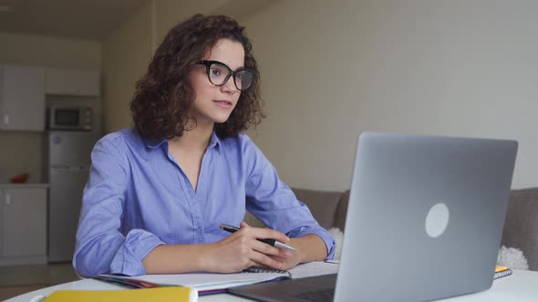 Serious Hispanic Young Woman Freelancer Working Online on Computer Laptop