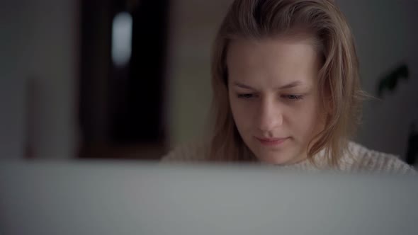 A Young Blond Girl Looking at the Laptop Screen While Working or Studying