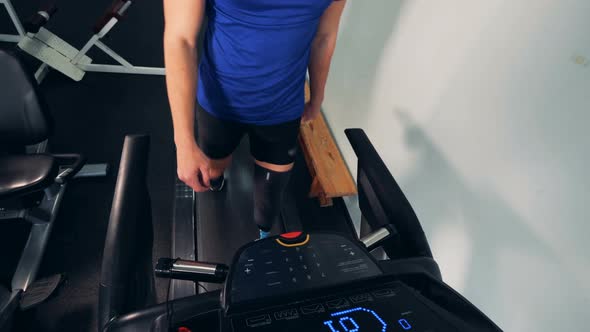 A Man with Prosthetic Leg Walks on a Treadmill