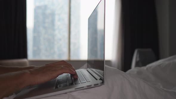 Close Up of Hands of a Person in Bed Typing on Laptop