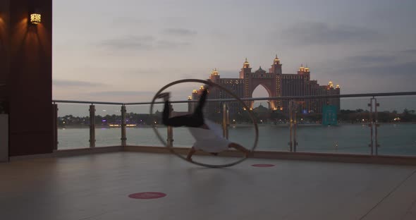 Professional Wheel Gymnast is Spinning in a Wheel with Amazing View Behind
