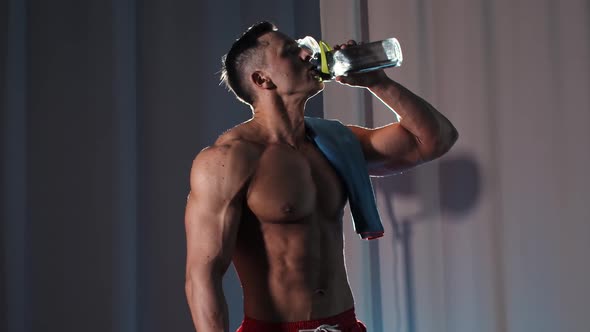 Sports Training  Athletic Muscular Shirtless Man Drinking Water From the Plastic Bottle