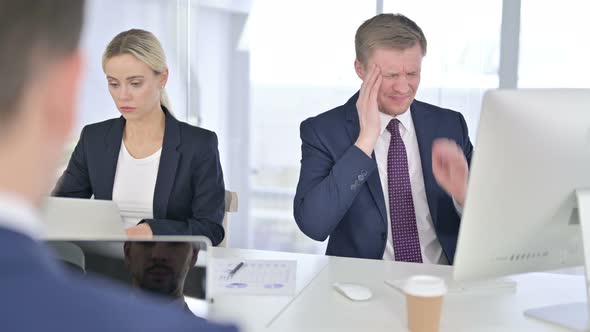 Tired Businessman Having Headache in Modern Office