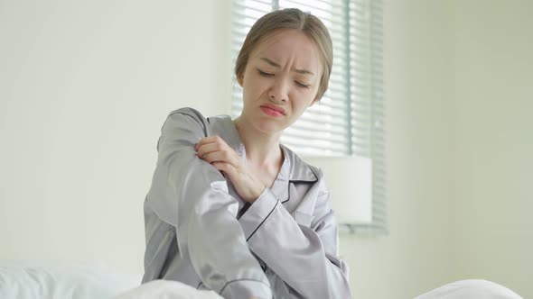 Young Caucasian woman scratching hands after wake up in the morning.