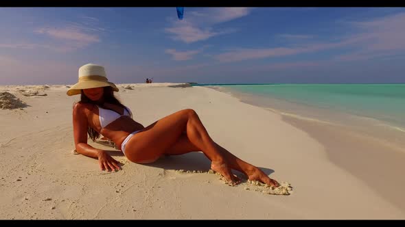 Single female sunbathing on luxury resort beach time by clear lagoon with bright sandy background of