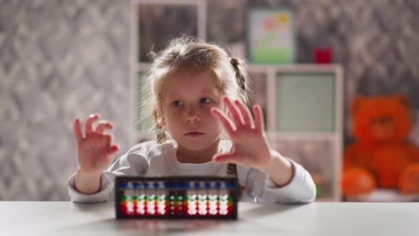 Little Girl Student with Abacus Does Exercises for Fingers