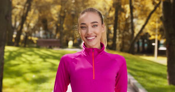 Outdoor Portrait of Happy Sportive Woman Smiling To Camera in Autumn Park