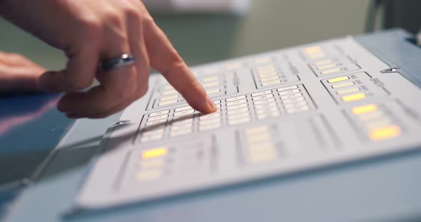 Close Up of Industrial Worker Hand Pushing Buttons on Operating Machine at Factory