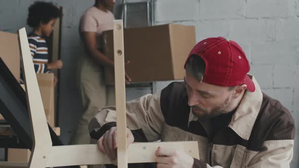 Handyman Assembling Wooden Chair during Move