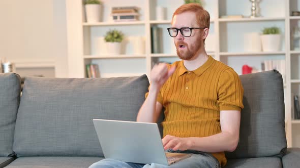 Redhead Man Working on Laptop and Coughing at Home 