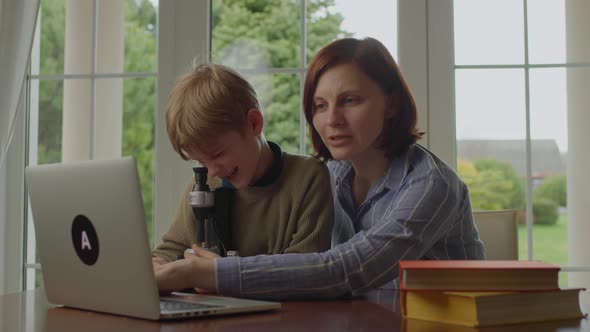 Young Mother Helping Her School Kid with Education From Home