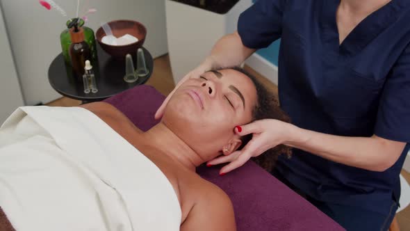 Skilled Beautician Applying Antiaging Face Massage Technique Indoors