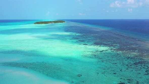 Wide birds eye clean view of a sunshine white sandy paradise beach and aqua blue ocean background in