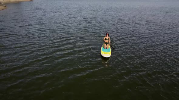 Caucasian Woman Riding a SUP Board on the Lake