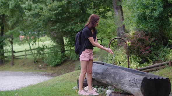 Woman Washes Her Hands in Spring Water