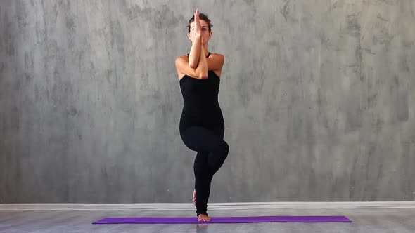 Woman is Engaged in Yoga in the Studio with Natural Bracing on a Purple Sports Mat