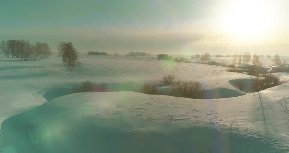 Aerial View of Cold Winter Landscape Arctic Field Trees Covered with Frost Snow Ice River and Sun