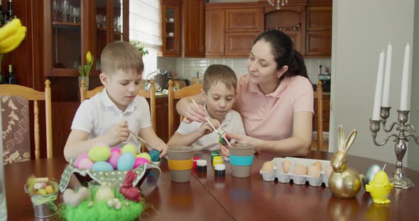 Mom Helps Her Sons Paint Easter Eggs