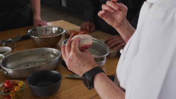 Caucasian female chef teaching diverse group