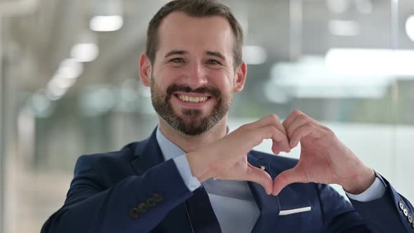 Portrait of Happy Businessman Showing Heart Sign with Hand