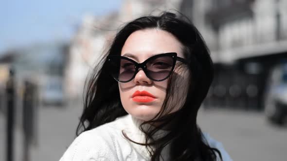Close Up of Joyful Young Hipster Girl with Balck Hair and Sunglasses and Red Lips