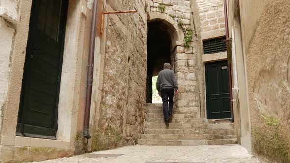 Tourist man walking through an alley in the streets of Dubrovnik 