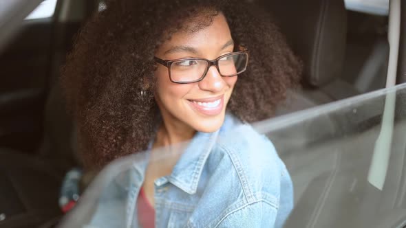 Happy Young Smiling African American Woman Black Haired Driver in Glasses Sitting in New Brown Car