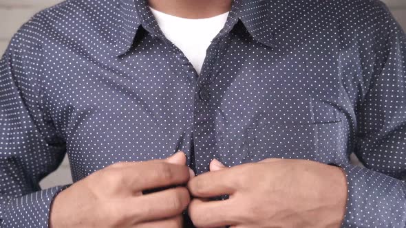 Man Buttoning His Shirt Close Up