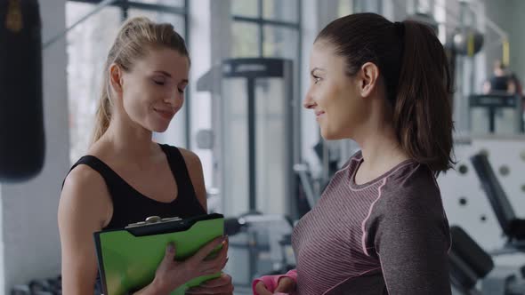 Fitness instructor and woman chatting before gym session.  Shot with RED helium camera