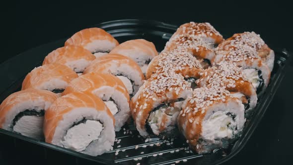 Sushi Rolls Rotating in Plastic Box