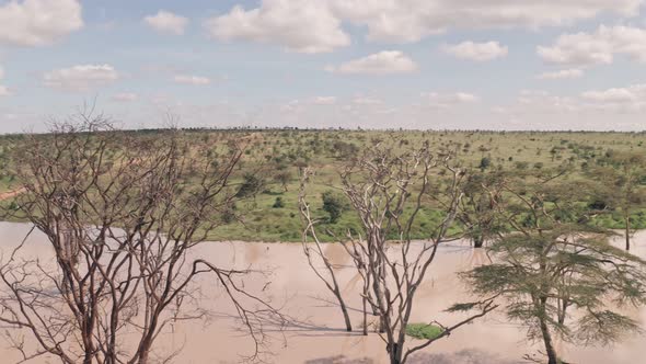 Waterhole lake in Laikipia, Kenya. Aerial spinning drone view of Kenyan landscape