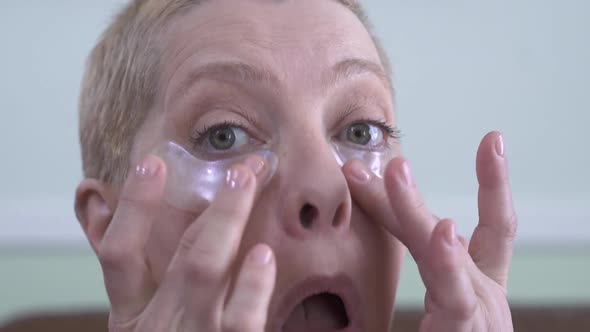 Happy Beautiful Mature Woman Removing Eye Patches and Looking at Camera with Amazing Big Smile