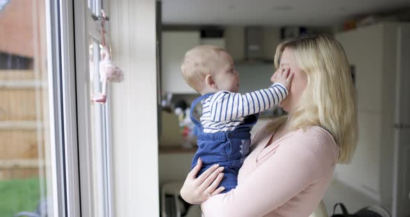 Young mother playing with her newborn baby boy in the living room