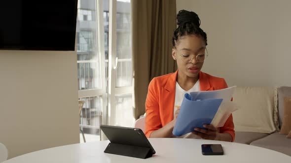 Africanamerican Businesswoman Discussing a Report on a Video Call From Home