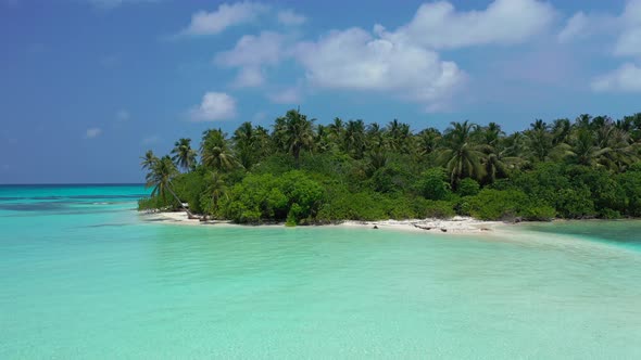 Tropical flying travel shot of a sunshine white sandy paradise beach and aqua blue ocean background 