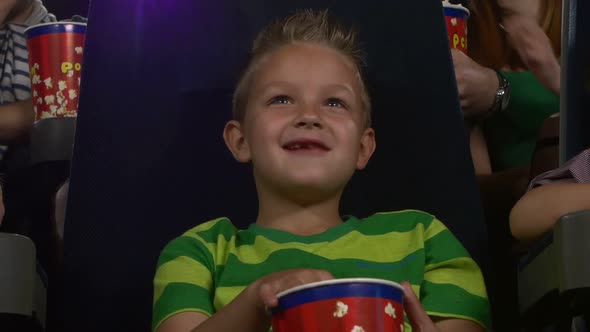 Happy Boy with Popcorn Watching a Movie. Close Up