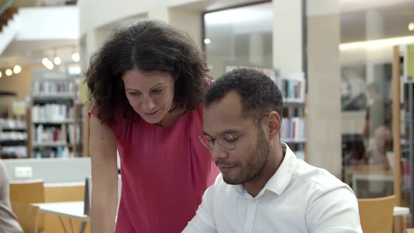 Cheerful Colleagues Communicating at Library