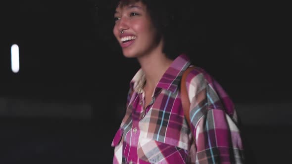 Slow motion shot of smiling young woman dancing at night