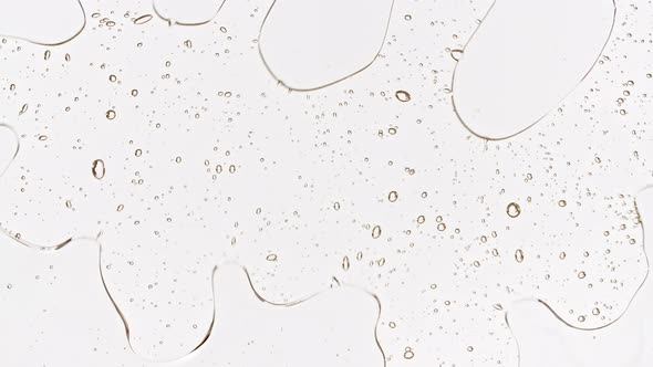 Transparent Cosmetic Gel Fluid with Bubbles Oil on Water Silver Colored Background