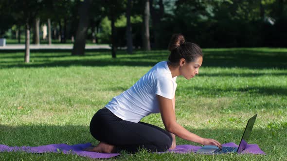 Woman Yoga in the Park Working on a Laptop