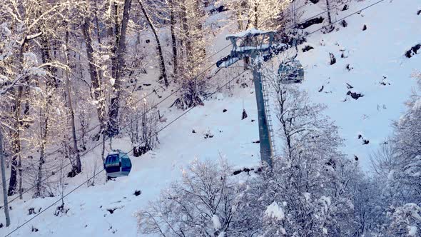 Lift Cabins In A Mountain Ski Resort Go Up And Down The Snowy Slope,