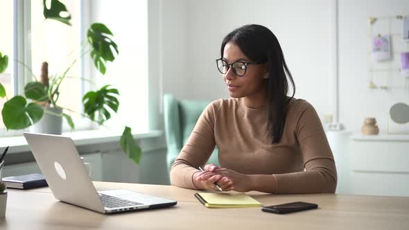 African Woman with Glasses in Front of Laptop Leads an Online Consultation Spbd