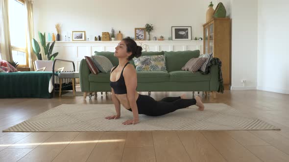 Middle-aged Indian woman practice yoga sun salutation Body care morning routine at cozy interior