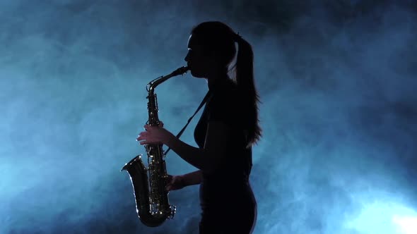 Silhouette Musician Female Playing on Saxophone. Smoky Studio, Slow Motion