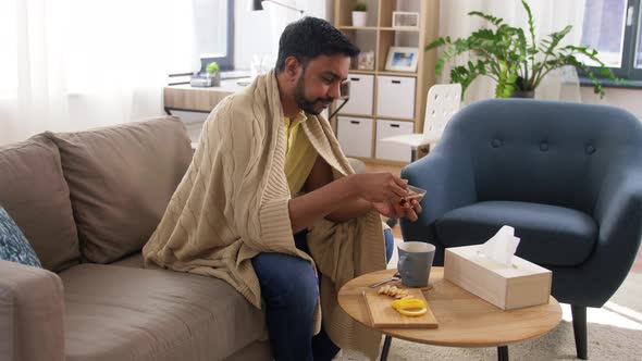 Sick Indian Man Adding Honey To Hot Tea at Home