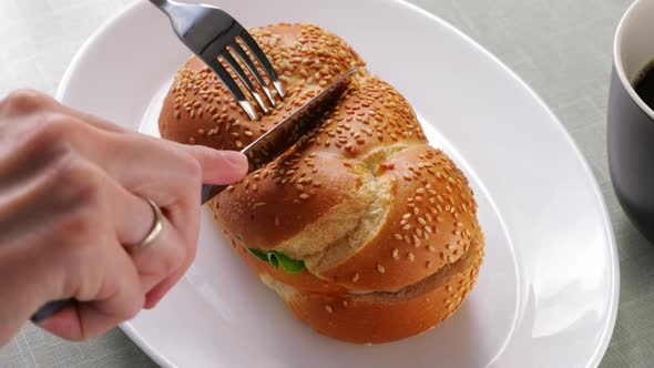 Cafe Client Puts a Sandwich with a Bun Tuna and Tomato with Cucumbers on a White Plate on the Table