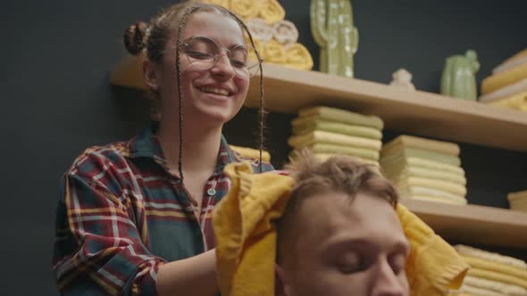 Barbershop: female barber washes the head of male client