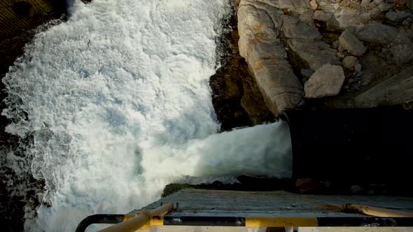 Effluents from large black plastic pipe being discharged into ocean