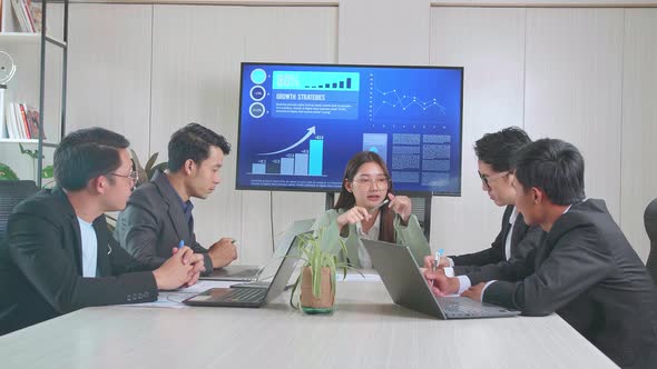 Young Asian Businesswoman Leader Meeting With Her Team. They Are Sitting In The Conference Room